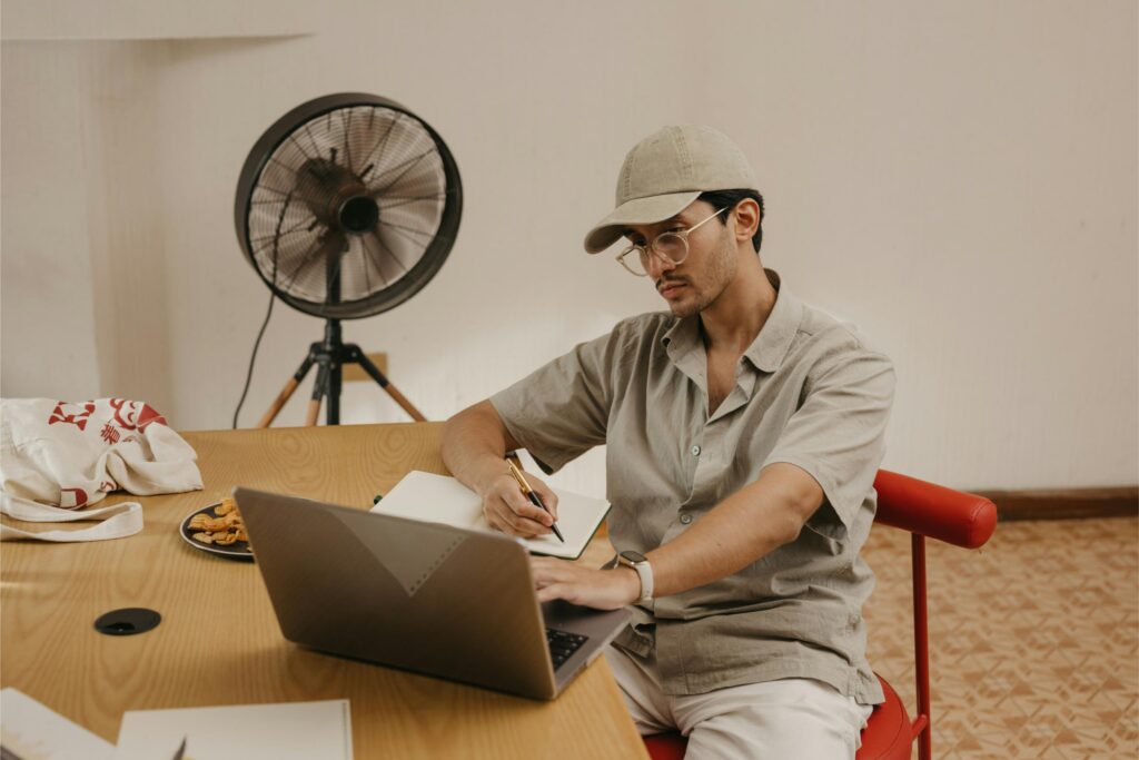 Worker using laptop in a home office, contemplating work from home burnout