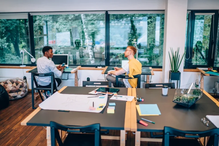 Two men talking in a coworking space, enjoying its benefits