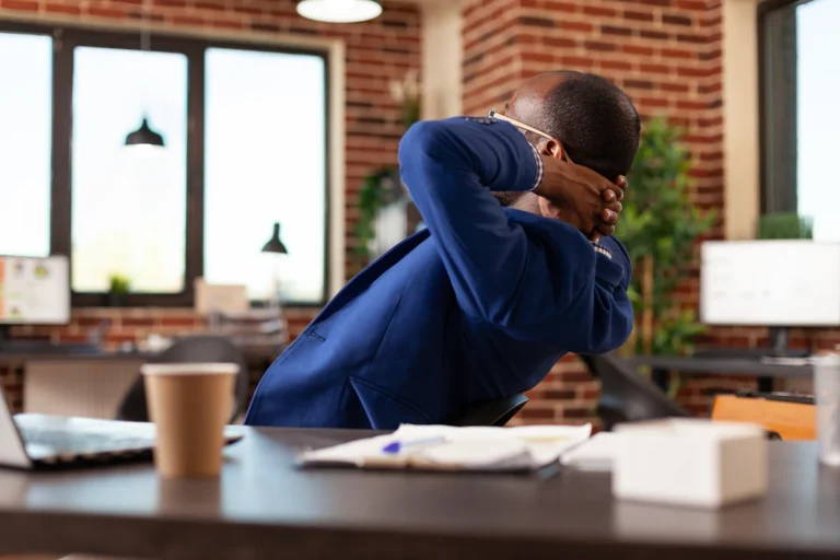 Entrepreneur taking a break from work to look out a window, trying to overcome creative block